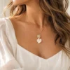 Collier STELLA porté avec un décolleté en V blanc : pendentif zircones et pétales de porcelaine au creux du cou, by Marguerite