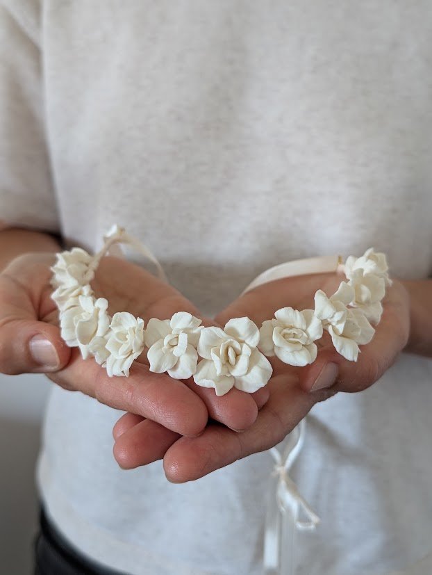 Ma façon de créer : en petite série, pétale après pétale 4 Couronne de roses en porcelaine froide blanche nouée d'un ruban de satin, présentée dans mes mains, by Marguerite
