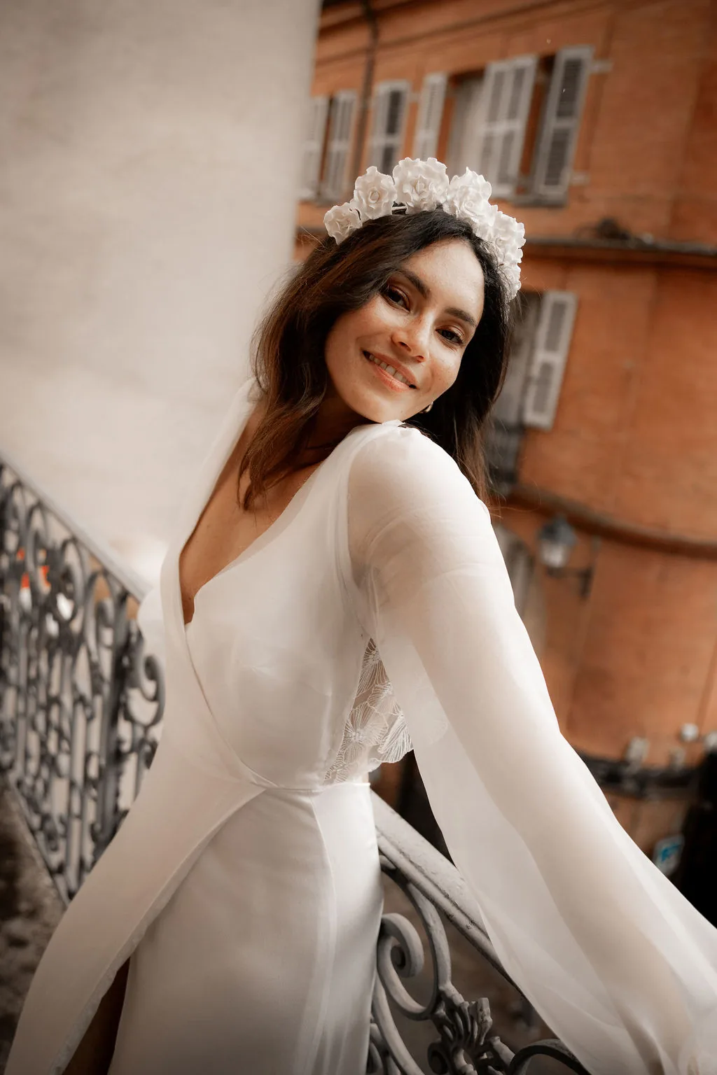 Accueil 20 Mariée souriante sur un balcon en fer forgé, couronne JEANNE en roses de porcelaine, by Marguerite