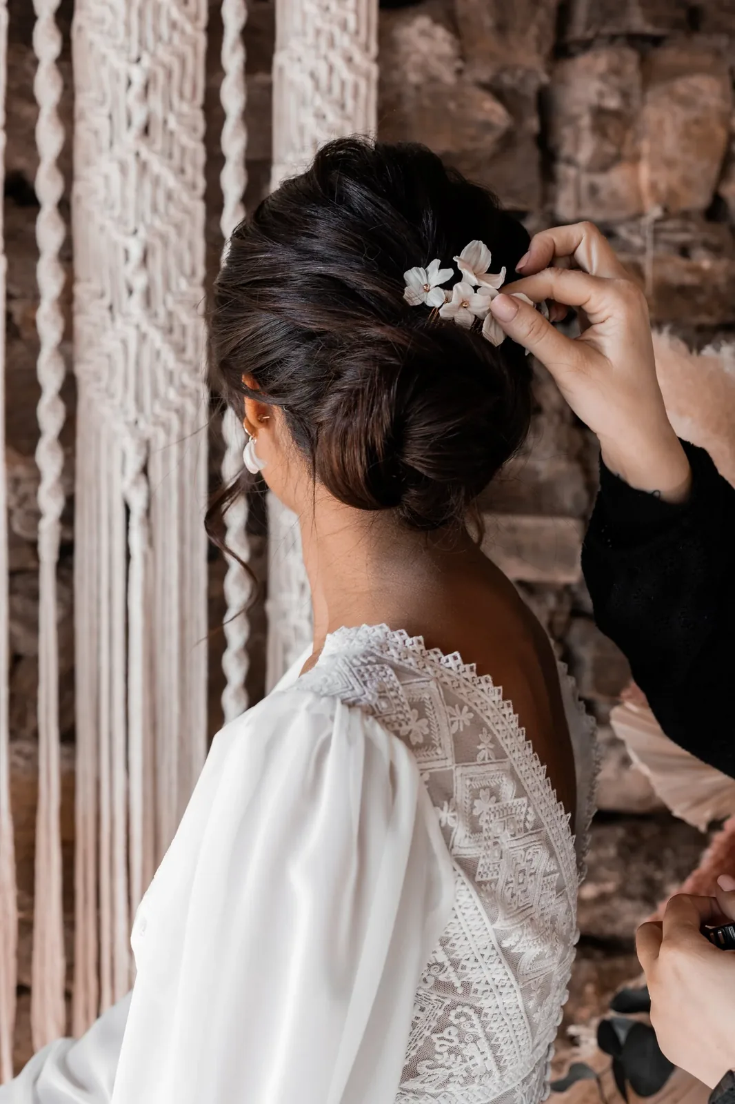 Coiffeuse posant le peigne GARANCE dans un chignon flou de mariée, by Marguerite
