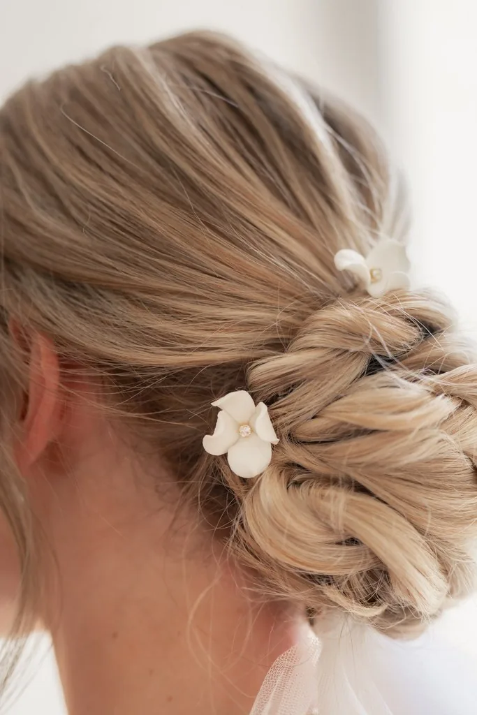 Chignon de mariée blond orné d'une fleur blanche en porcelaine froide, by Marguerite