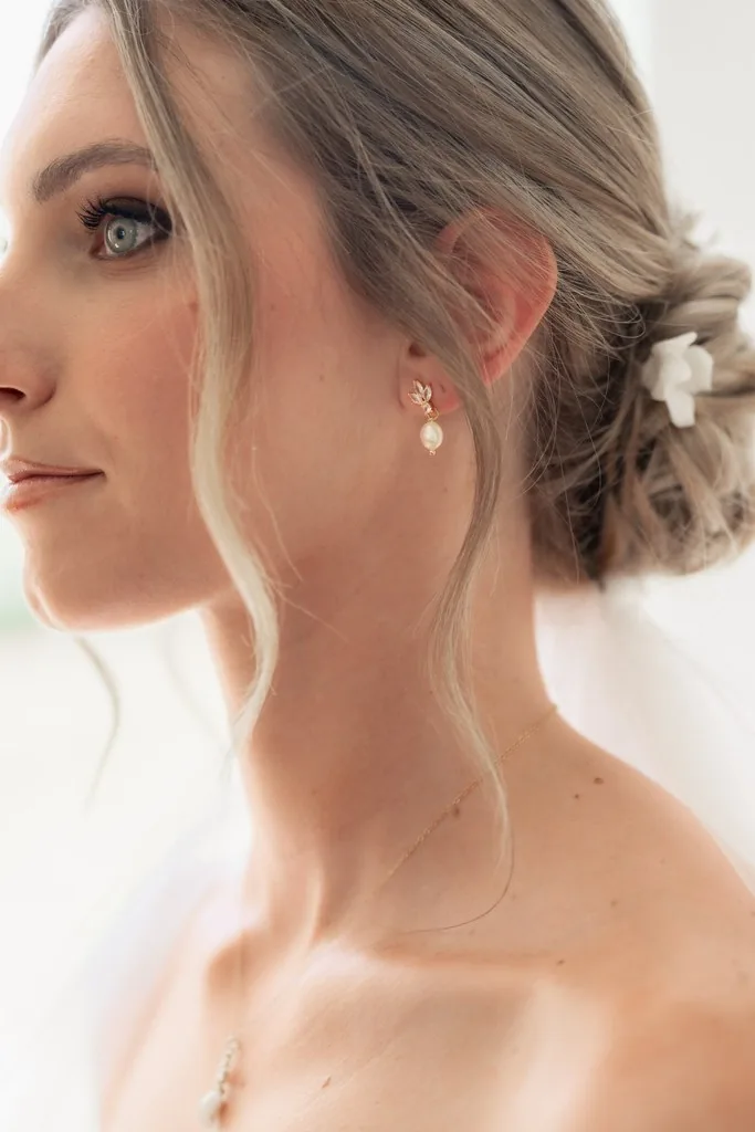 Mariée de profil, boucle d'oreille perle et fleur de porcelaine dans le chignon, by Marguerite