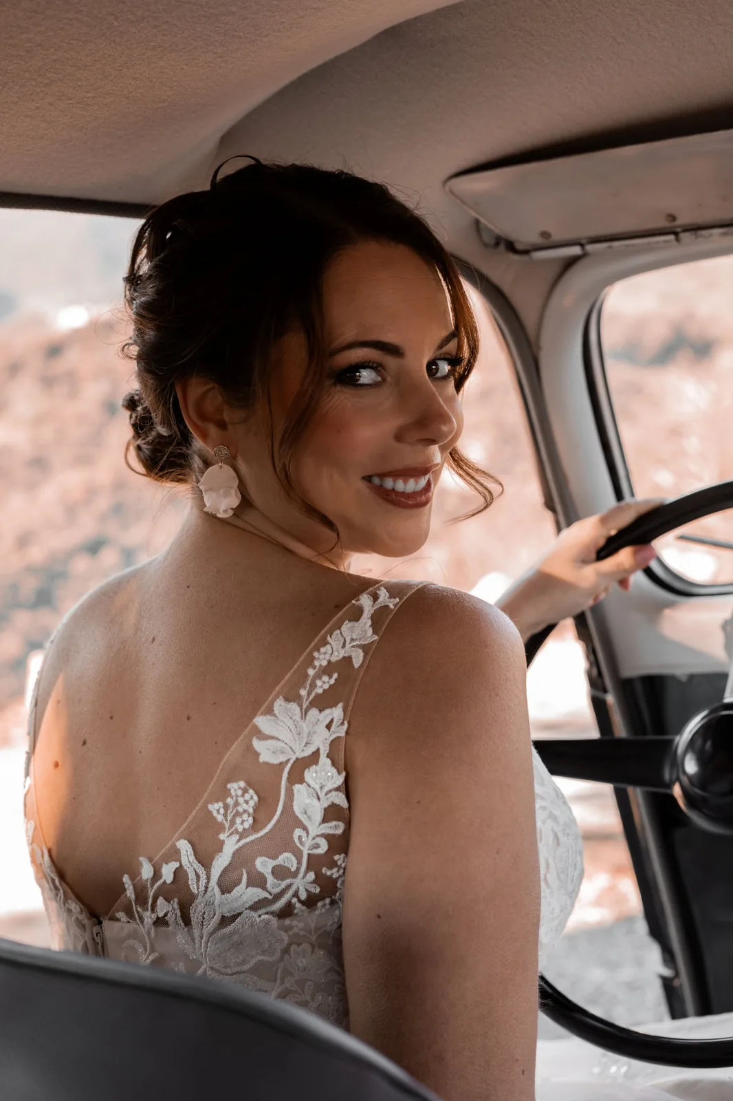 Accueil 23 Mariée au volant d'une voiture ancienne, se retournant avec le sourire, boucles d'oreilles DIANE en pétale de porcelaine, by Marguerite